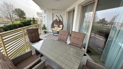 d'un balcon avec une table et des chaises en verre. dans l'établissement Amber Sea Apartmens, à Sianożęty