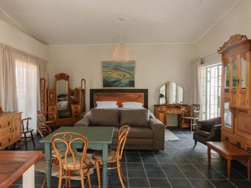 a living room with a bed and a table and chairs at Kokerboom House in Vanrhynsdorp