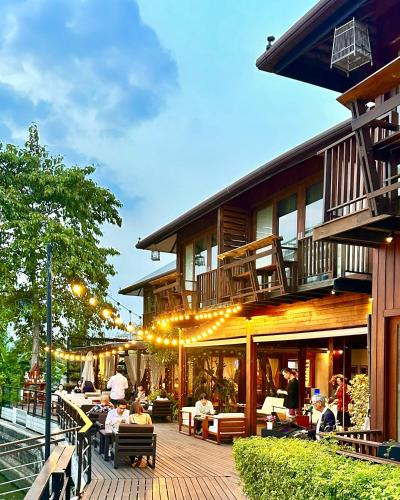 a group of people sitting on a patio outside of a building at Chann Bangkok Noi in Bangkok