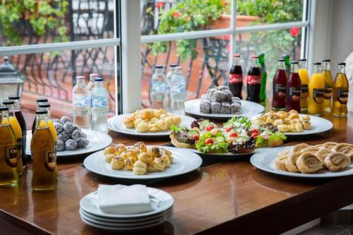 a table with plates of food and bottles of drinks at Bodrogi Kúria Wellness Hotel in Inárcs