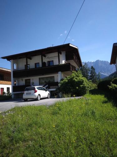 a white car parked in front of a building at Alpenstern in Biberwier