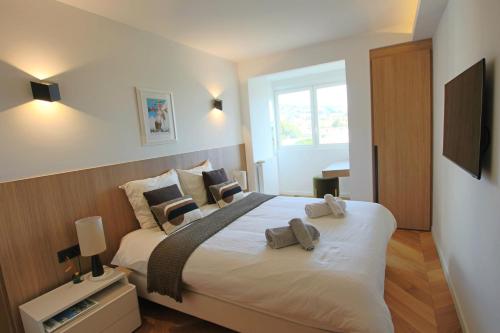 une chambre avec un grand lit blanc avec deux oreillers dans l'établissement COMPLETELY RENOVATED APARTMENT ON BLD CROISETTE, 3 PARENTAL BEDROOMS, à Cannes