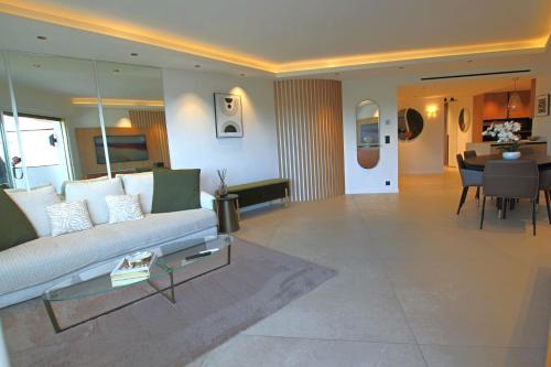 un salon avec un canapé et une salle à manger dans l'établissement COMPLETELY RENOVATED APARTMENT ON BLD CROISETTE, 3 PARENTAL BEDROOMS, à Cannes