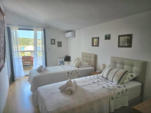 1 dormitorio con 2 camas y balcón en Bellavista Apartment, en Stara Novalja