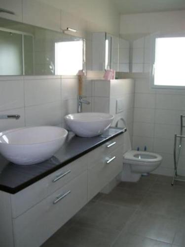 une salle de bain avec deux lavabos et un WC dans l'établissement Maison au calme avec vue sur mer 200 m de la mer, à Bretignolles-sur-Mer