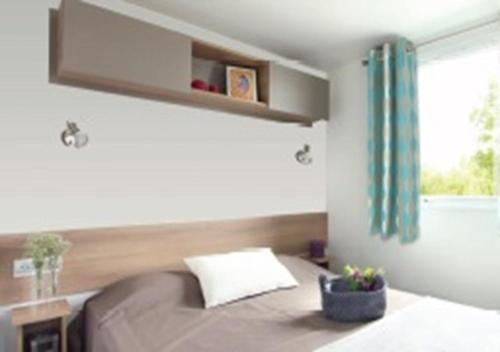 um quarto com uma cama e uma janela em Mobil-home Clim, Tv, Lv - Camping Lac des Rêves 4 étoiles - 010 em Lattes