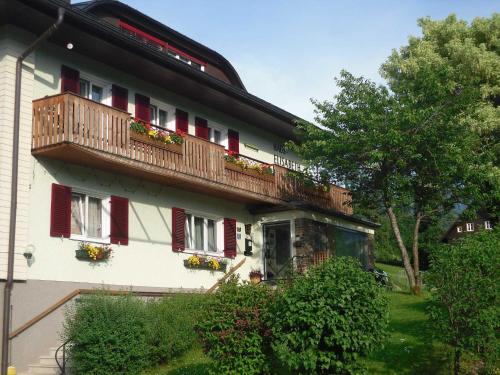 a building with red shuttered windows and a balcony at Ferienwohnungen Haus Elisabeth in Bad Goisern