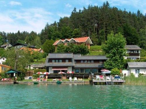 a house on the shore of a body of water at Ferienwohnungen Mistelbauer DIREKT am Faaker See in Egg am Faaker See
