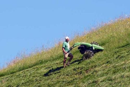 Un uomo che cammina su una collina con una moto di Haus Häsischa - Biobauernhof im Biosphaerenpark - a Marul