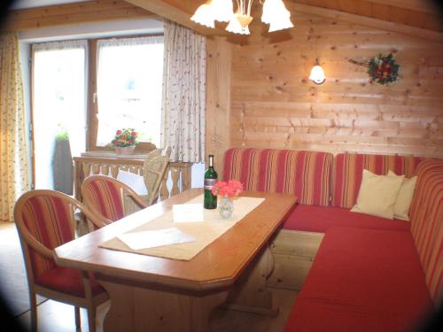 a dining room with a table with a bottle of wine at Appartements Wörgötter Astrid & Sepp in Rettenbach