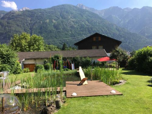 een houten terras in een tuin met een huis bij Haus Wallner in Dellach im Drautal