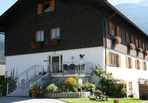 een groot wit huis met een zwart dak bij Haus Wallner in Dellach im Drautal