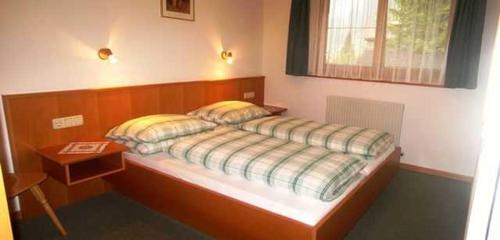 a bedroom with a bed and a table in it at Chalet Sonnblick in Äußere Großrotte