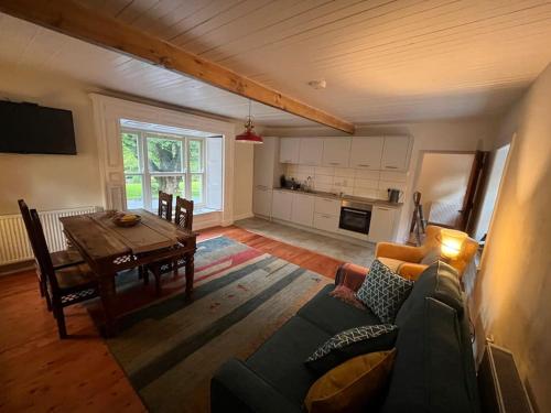 ein Wohnzimmer mit einem Sofa und einem Esstisch in der Unterkunft Wood House Lodge in Tipperary