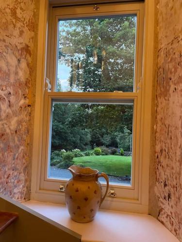 a vase sitting on a shelf in front of a window at Wood House Lodge in Tipperary