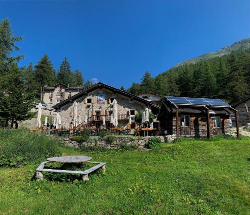 a large building with a picnic table in the grass at Chalet del Lago in Ceresole Reale