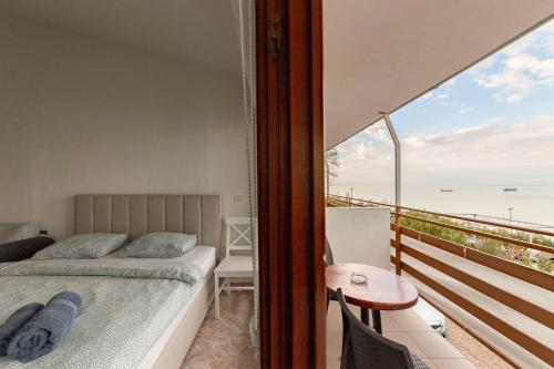 1 dormitorio con 1 cama y balcón con mesa en Apartma Gaja, en Koper