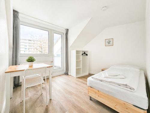 een slaapkamer met een bed, een bureau en een raam bij RAJ Living - 3 Zimmer Wohnung mit Balkon - 25 Min zur Messe DUS in Heiligenhaus