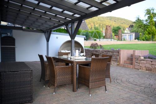 a patio with a table and chairs under a pergola at Die Nummer eins - Ferienwohnungen Hufnagel in Bodenwerder