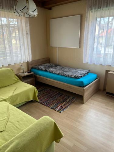ein Schlafzimmer mit einem Bett in einem Zimmer mit Fenstern in der Unterkunft Gästehaus Maria in Köflach