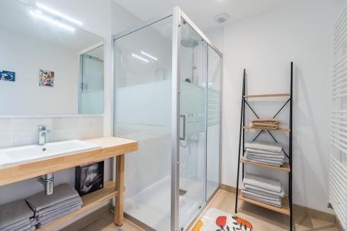 a bathroom with a glass shower and a sink at Appartement neuf Côte de Granit Rose - Ploumanac'h in Perros-Guirec