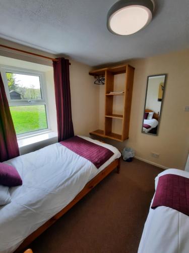 a bedroom with a bed and a window at Holiday Cottage 6 in Watermillock