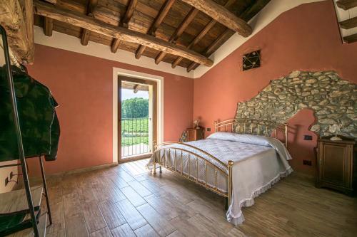 um quarto com uma cama e uma grande janela em Agriturismo Fontanassa em Gavi