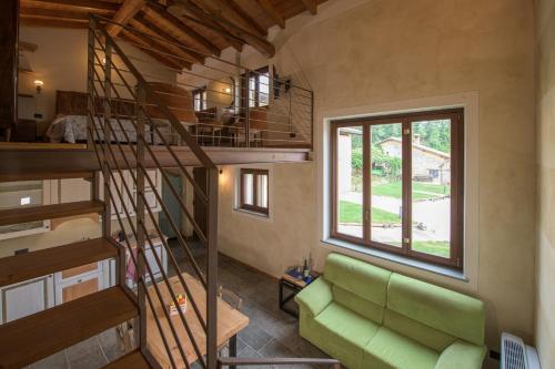 a living room with a green couch and a spiral staircase at Fontanassa ss in Gavi