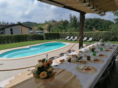 a table set for a meal next to a swimming pool at Fontanassa ss in Gavi