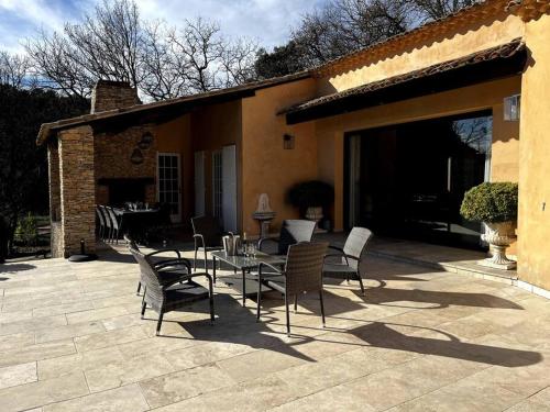 a patio with chairs and a table and a building at Domaine des Figons in Éguilles
