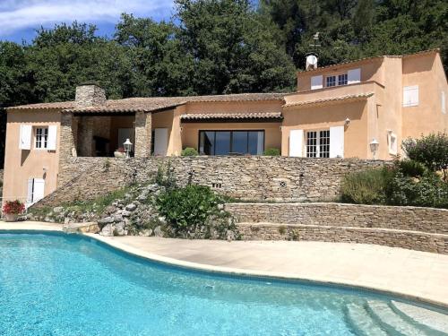 une maison avec un mur en pierre et une piscine dans l'établissement Domaine des Figons, à Éguilles