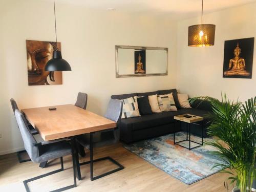 een woonkamer met een bank en een tafel bij City Zen Apartment Enschede !Free Private Parking in Enschede