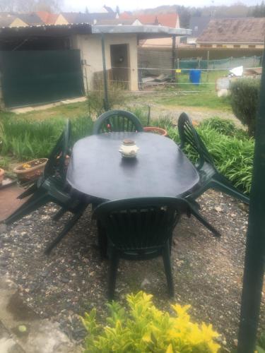 a table with two chairs and a cup on top at JARDIN DE CAMPAGNE in Ully-Saint-Georges