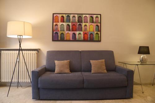 a blue couch in a living room with a painting at Milan Retreats in Milan