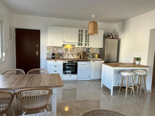 a kitchen with white cabinets and a table and chairs at M RESIDENCE in Petrcane