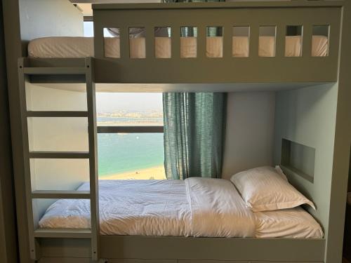 a bedroom with bunk beds with a view of the ocean at Dubai Town Jumeirah Beach Residence in Dubai