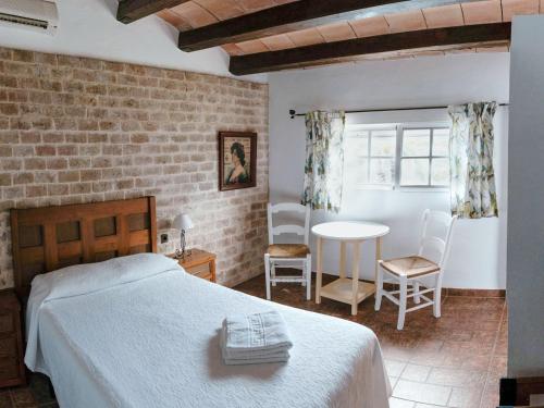 1 dormitorio con 1 cama, mesa y sillas en La Luciérnaga, en Chiclana de la Frontera