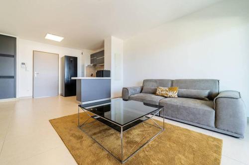 a living room with a couch and a glass table at L'Horizon- appartement 2 personnes à Bellepierre avec vue sur mer in Saint-Denis