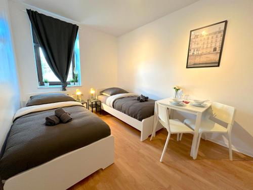 a bedroom with two beds and a desk and a table at Premium Unterkunft für Monteure und Geschäftsreisende : Vollausgestattet, WIFI & Washing in Lembruch