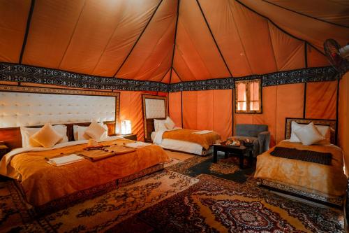 a bedroom with two beds in a tent at Sahara Luxury Camp in Merzouga