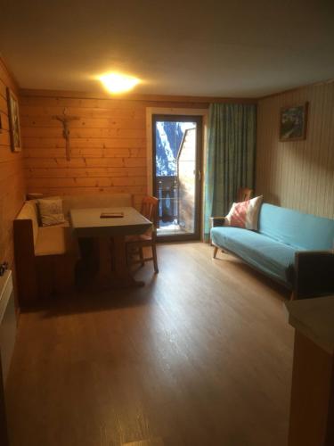 a living room with a blue couch and a table at Planerhof in Görtschach