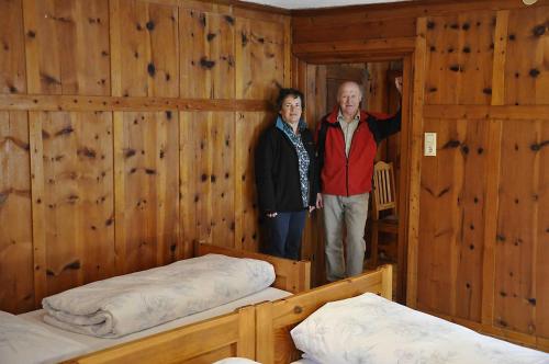 a man and woman standing in a room with two beds at Schweizerhof 