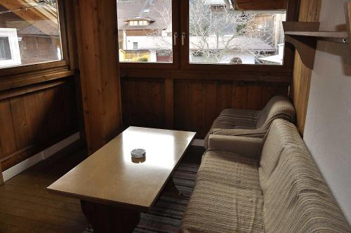 にあるSchweizerhofのソファ、テーブル、窓2つが備わる客室です。