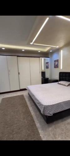 a bedroom with a large bed and white cabinets at الدقي شارع محي الدين ابو العز الرئيسي in Cairo