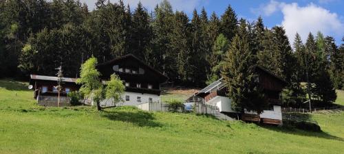 un gruppo di edifici in un campo alberato di Haus Lukasser ad Assling