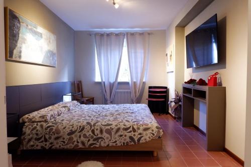 ein Schlafzimmer mit einem Bett und einem TV in der Unterkunft Casa Amore in Cannobio