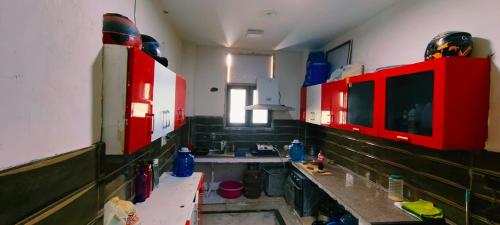 eine Küche mit roten Schränken und einem Waschbecken in der Unterkunft VB dormitory in Neu-Delhi