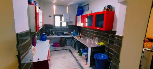 eine kleine Küche mit einer Spüle und roten Schränken in der Unterkunft VB dormitory in Neu-Delhi