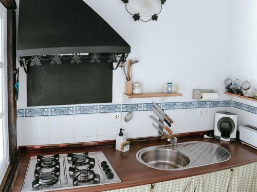 a kitchen with a sink and a stove at La Luciérnaga in Chiclana de la Frontera