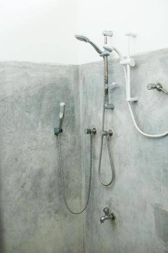 a shower in a bathroom with a shower head at Relax Beach House in Tangalle